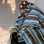 Un mendigo se protege con una manta en Madrid