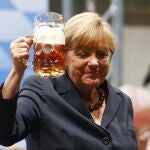 La canciller Angela Merkel brinda con una cerveza tras un mitin electoral en Múnich