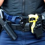 Pistola eléctrica táser en el cinturón de un policía - Archivo