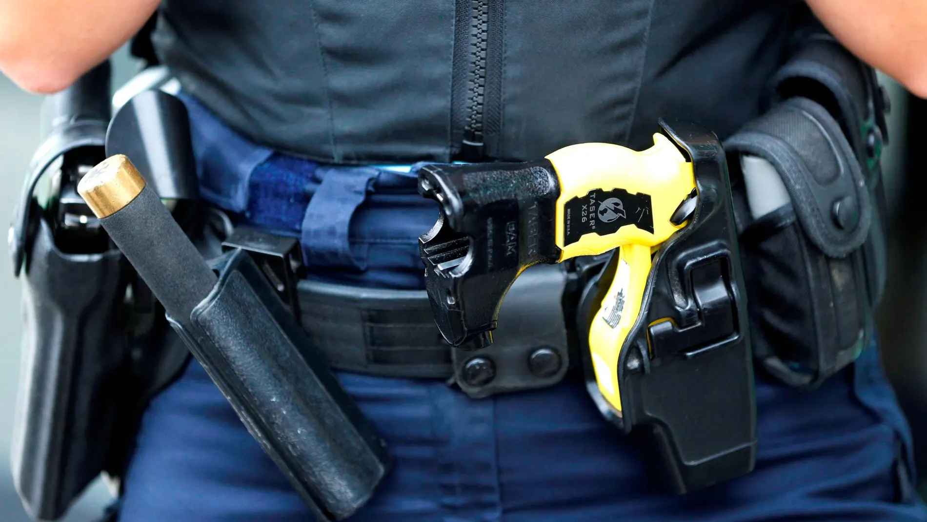Pistola eléctrica táser en el cinturón de un policía - Archivo