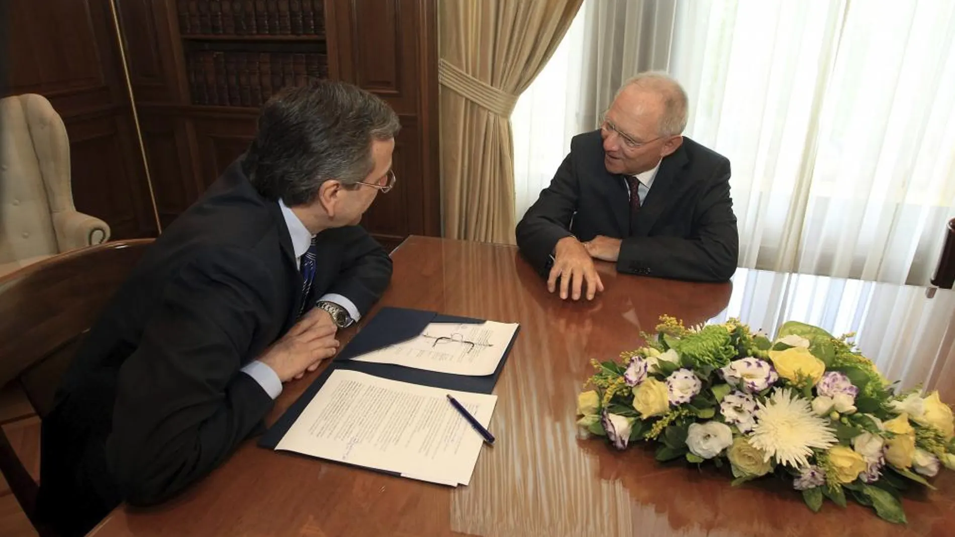 El ministro de Finanzas alemán, Wolfgang Schäuble (d), conversa con su homólogo griego, Antonis Samarás, durante una reunión en Atenas (Grecia), hoy, jueves 18 de julio de 2013.