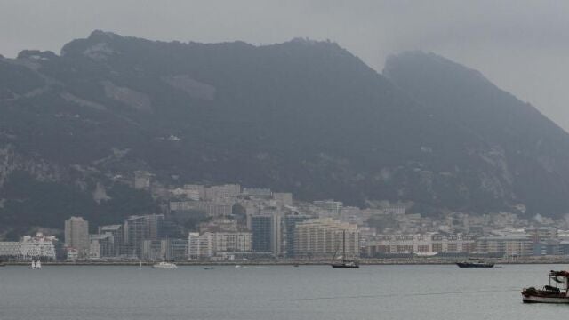Un barco pesquero navega por la bahía de Algeciras con Gibraltar al fondo