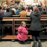 Una niña mira hacia atrás mientras se celebra la misa por la visita del Papa Francisco a Rumanía en la catedral de Bucarest