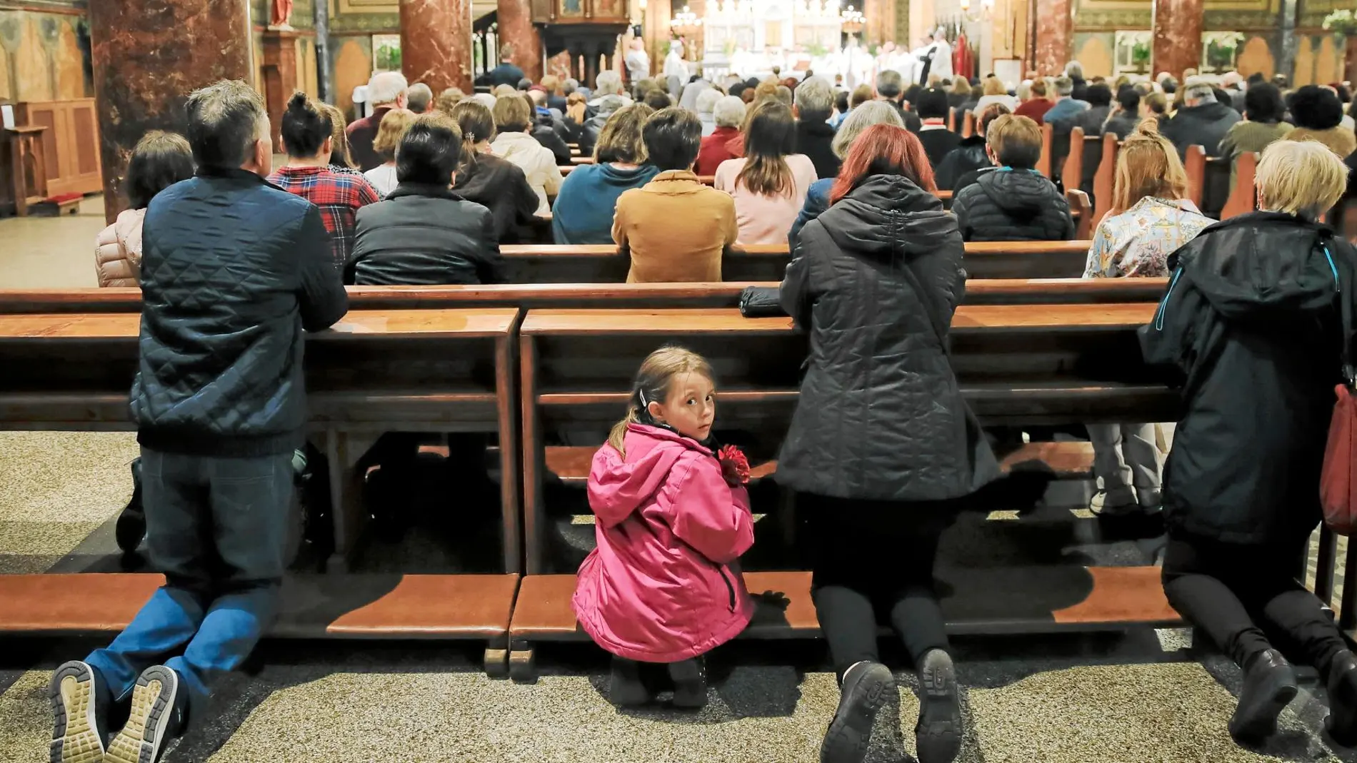Una niña mira hacia atrás mientras se celebra la misa por la visita del Papa Francisco a Rumanía en la catedral de Bucarest
