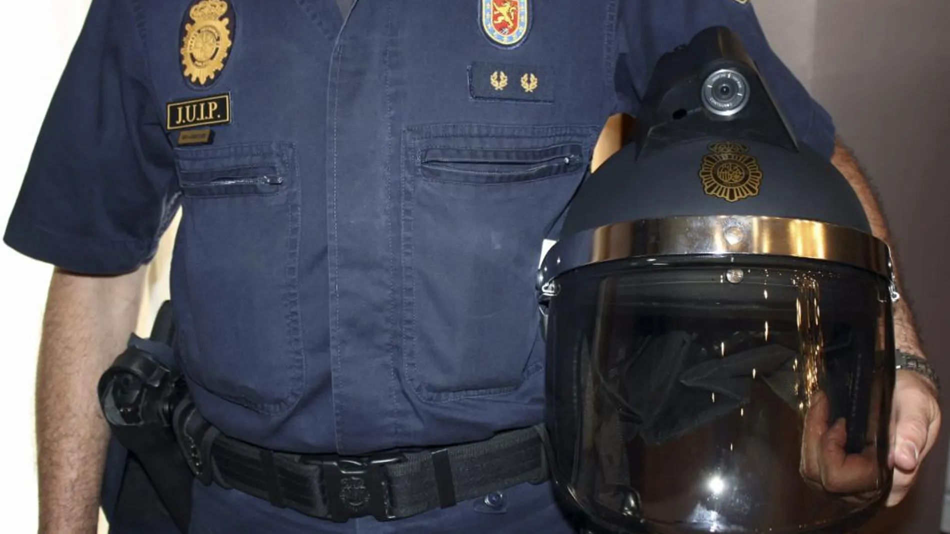 Fotografía facilitada por la Policía Nacional de un agente con uno de los 18 cascos con cámara que la Real Federación Española de Fútbol (RFEF) ha entregado hoy a la Policía Nacional