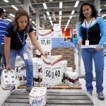 Empleadas de un supermercado en Caracas reponen existencias de papel higiénico