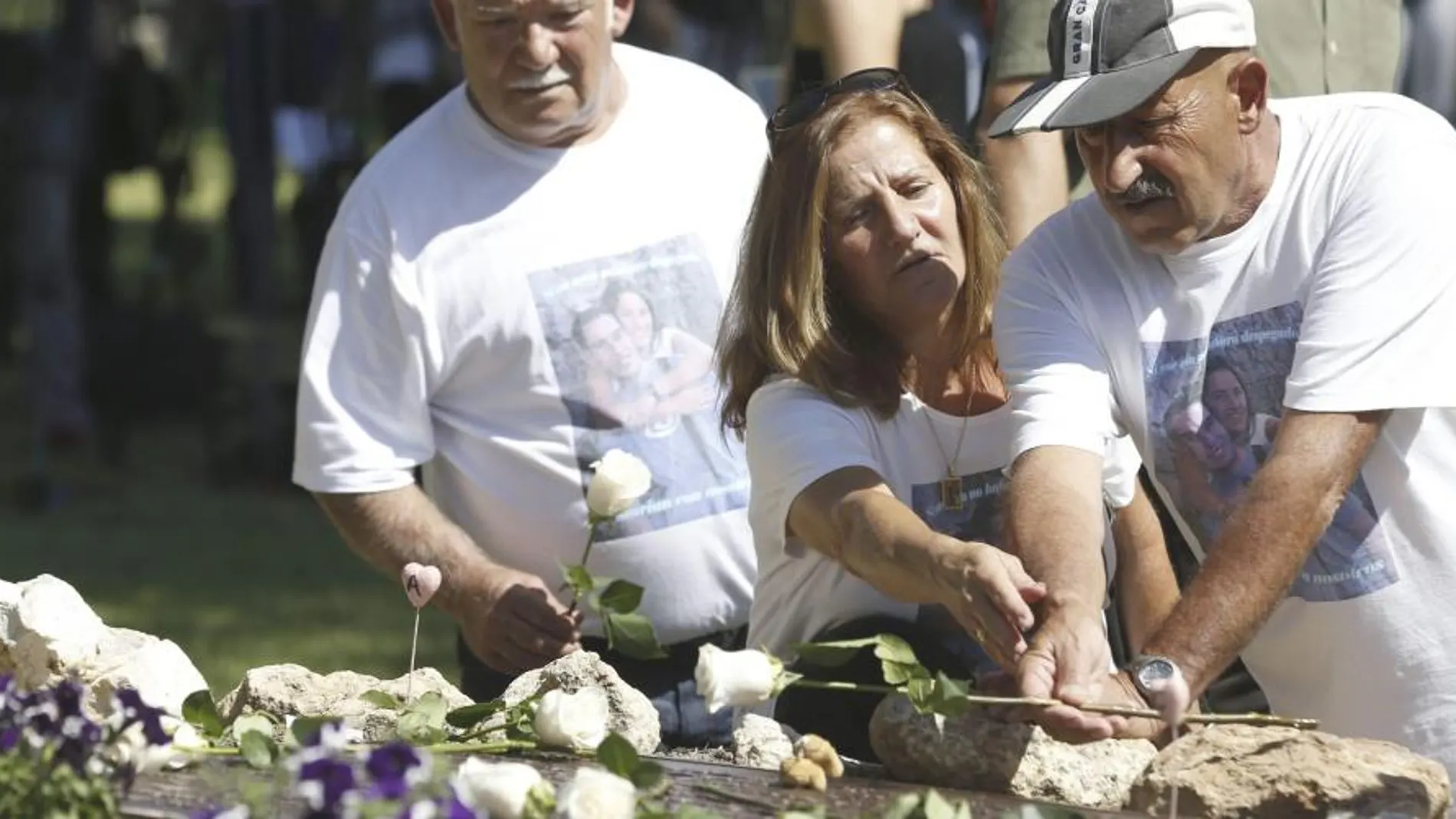 Familiares y afectados de la tragedia del avión de Spanair durante la ofrenda floral al pie del olivo situado en los jardines de la Terminal 2 del aeropuerto de Barajas