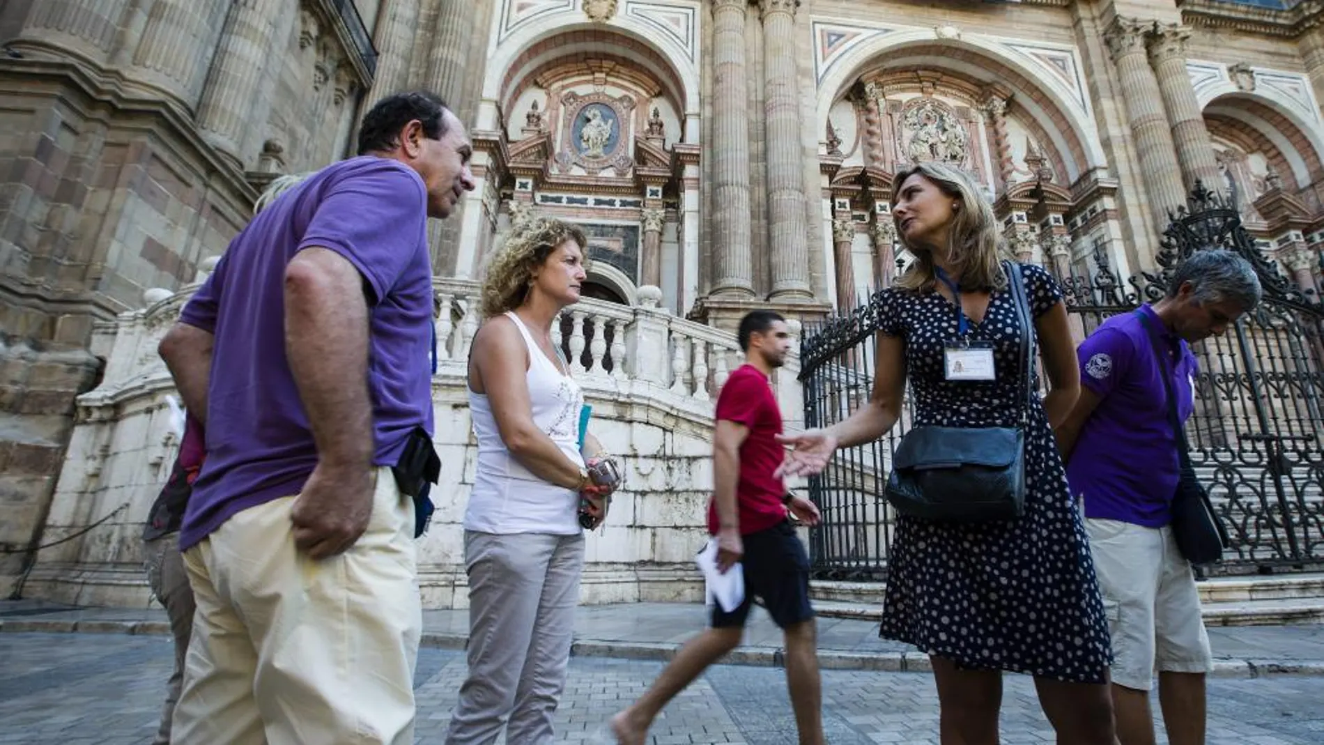 Una guía oficial muestra a un grupo de turistas la catedral de Málaga