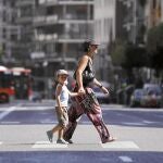 Una madre junto a su hijo cruzan una calle céntrica de Valencia