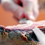 Un cortador se dispone a extraer una loncha de jamón