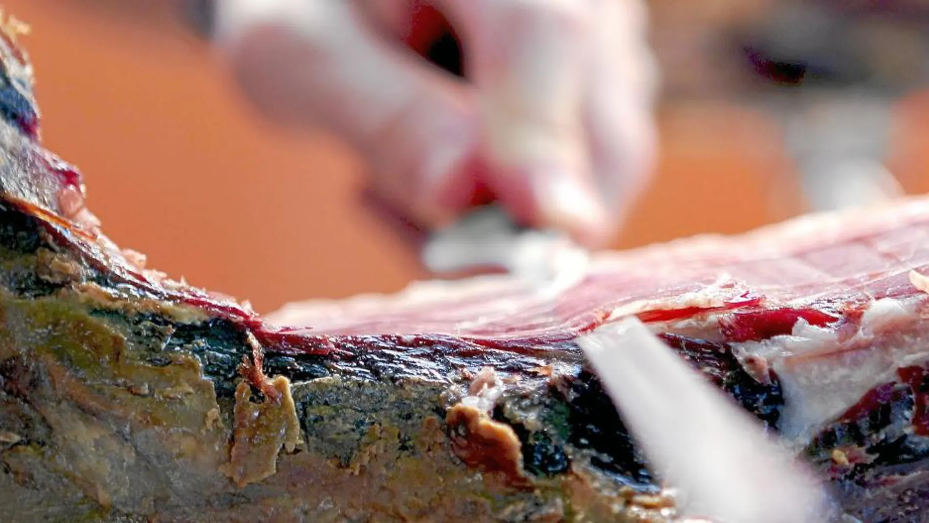Un cortador se dispone a extraer una loncha de jamón