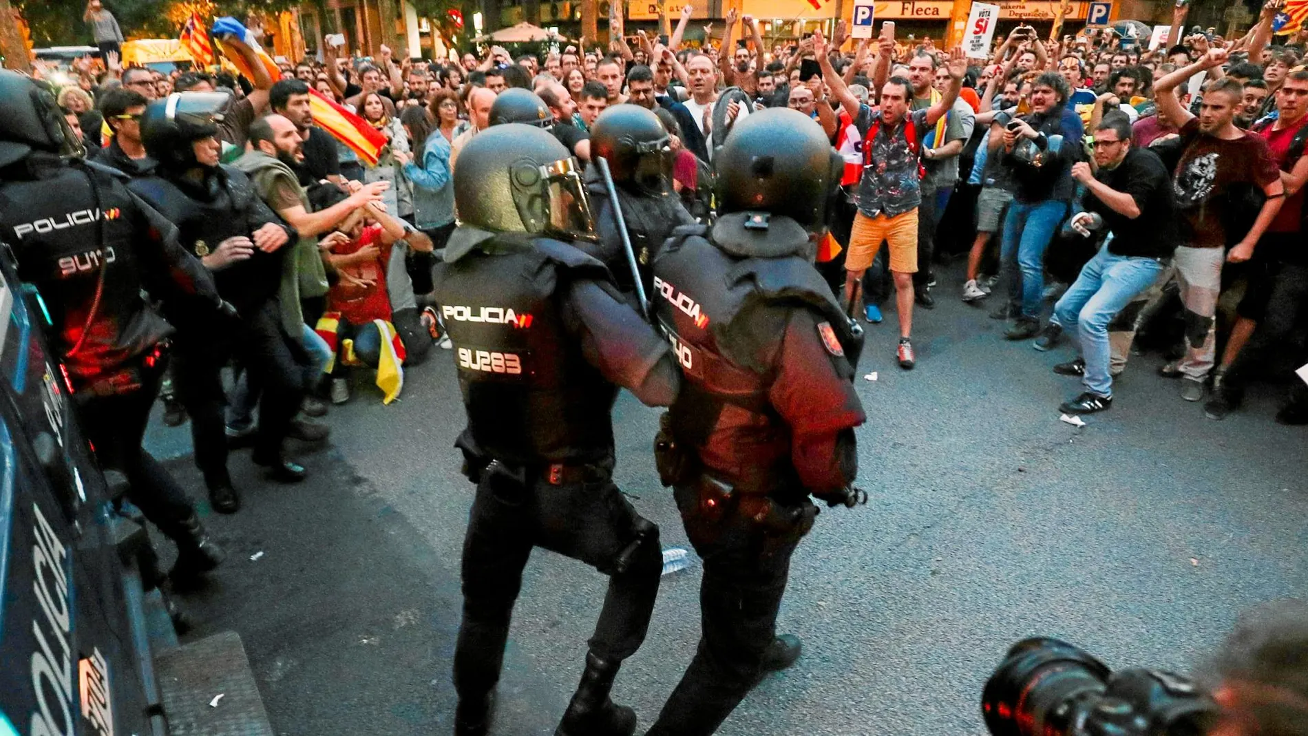 Varios agentes de Policía, rodeados por manifestantes durante el registro de la sede de la CUP el 20 de septiembre de 2017. Foto: REUTERS