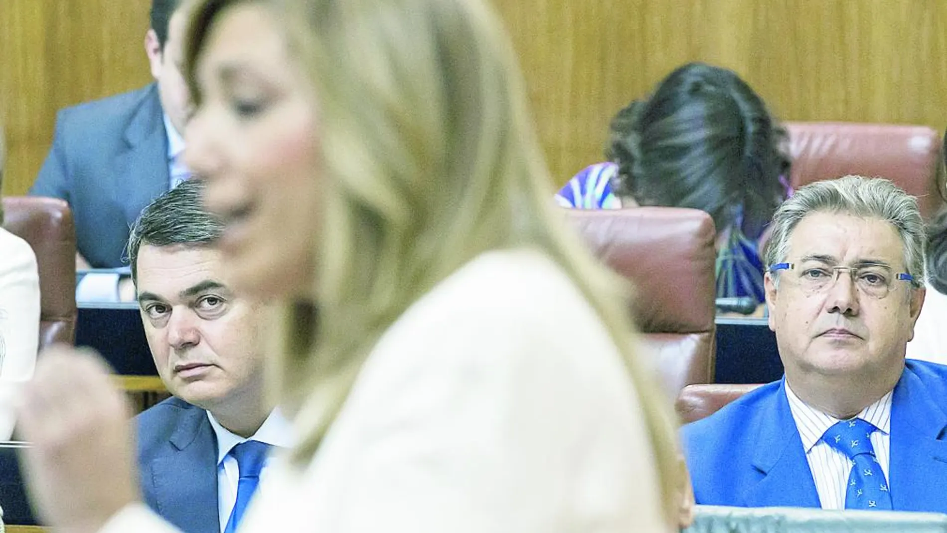 El presidente del PP andaluz, Juan Ignacio Zoido (d) y el portavoz de su grupo parlamentario, Carlos Rojas (i) escuchan a la presidenta de la Junta de Andalucía, Susana Díaz (c)