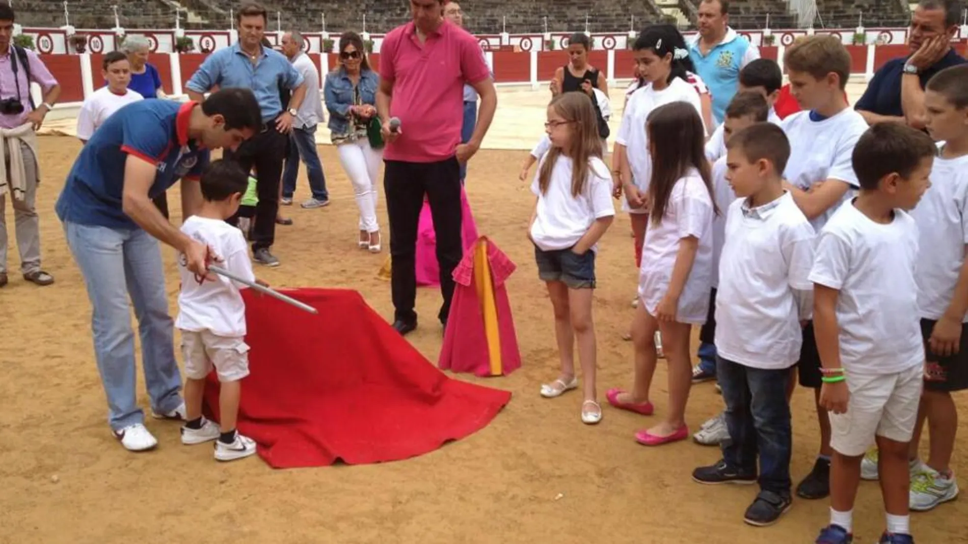 Castaño enseña a torear de muleta a un niño con El Tato como testigo
