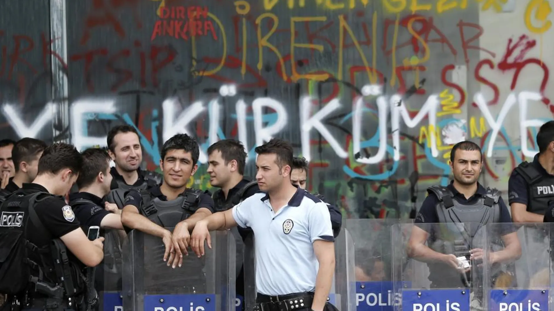 Policías turcos antidisturbios delante de una sucursal bancaria dañada en la plaza Taksim de Estambul
