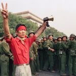 En esta foto de archivo, de 1989, un estudiante a favor de la democracia muestra el símbolo de la victoria a una muchedumbre de soldados del Ejército Popular Chino, en el lado oeste, cerca de la plaza de Tiananmen, en Pekín/AP