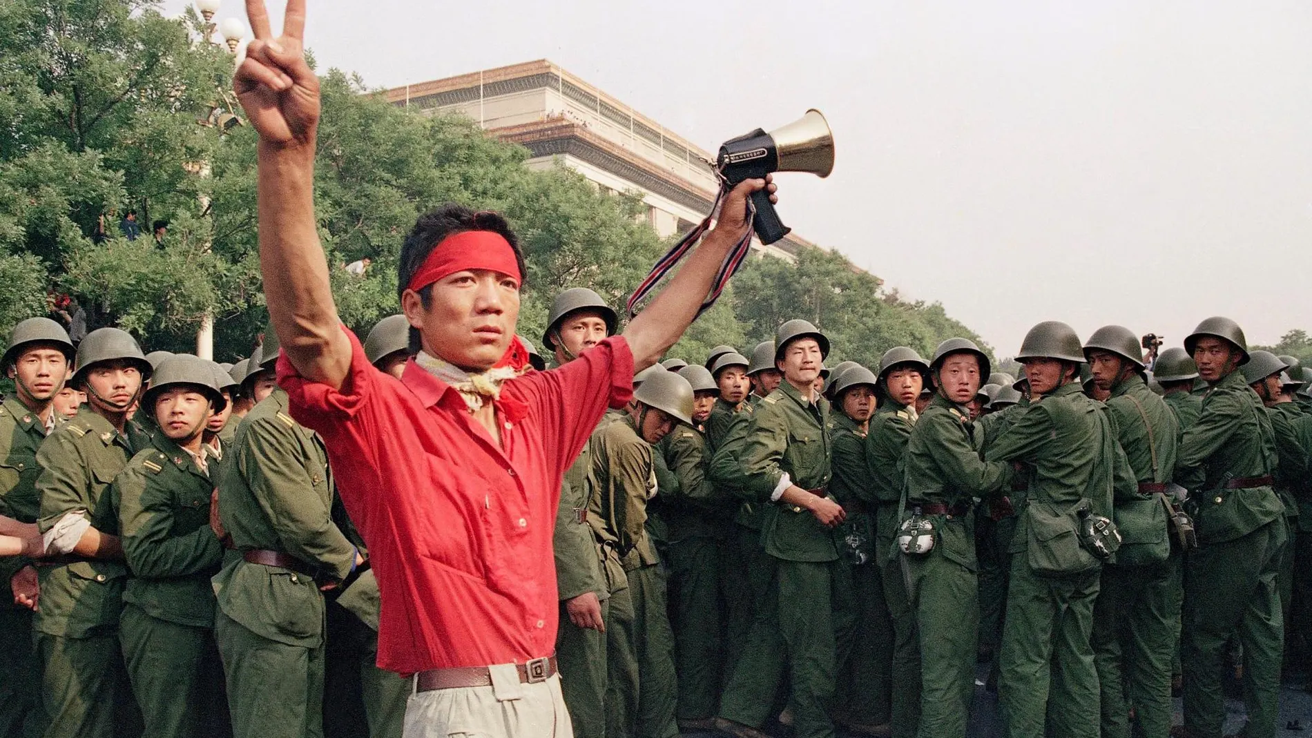 En esta foto de archivo, de 1989, un estudiante a favor de la democracia muestra el símbolo de la victoria a una muchedumbre de soldados del Ejército Popular Chino, en el lado oeste, cerca de la plaza de Tiananmen, en Pekín/AP
