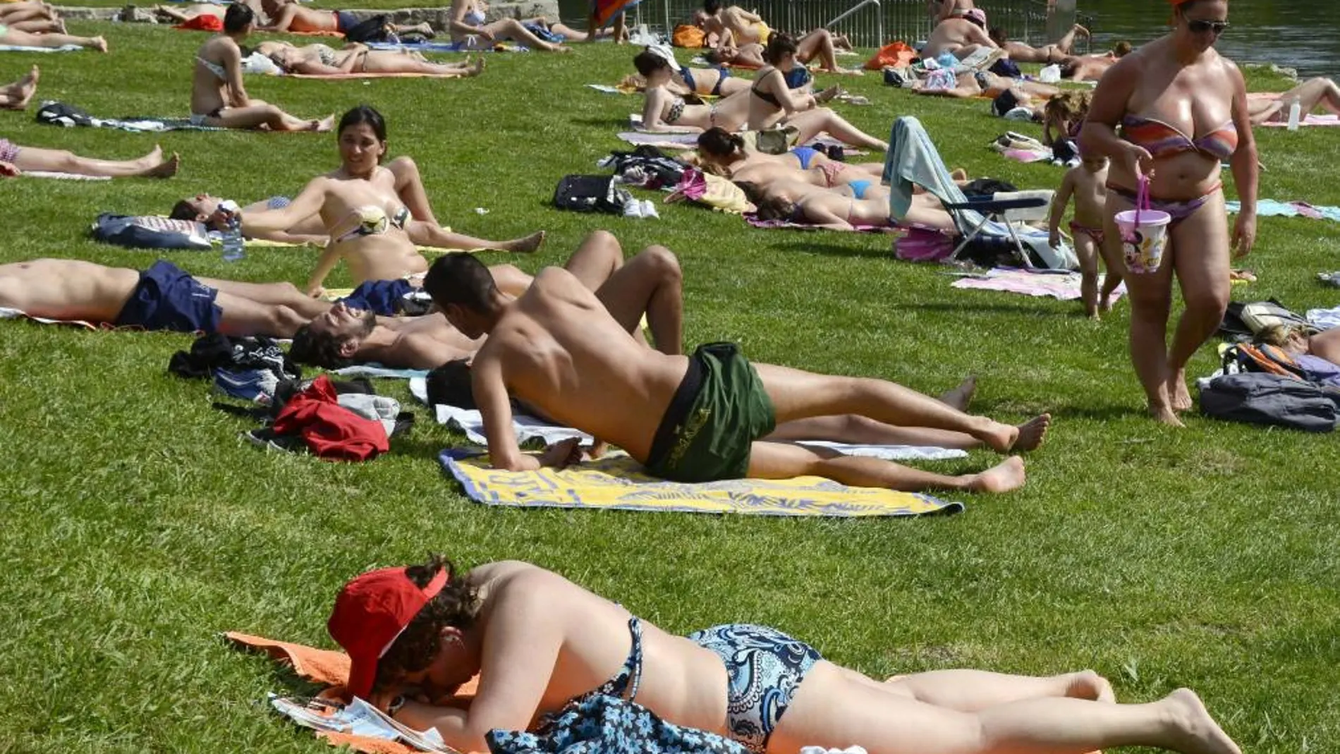 Imagen de archivo de varias personas toman el sol a la orilla del Miño, en Orense