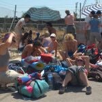 Varios jóvenes que asisten al Festival Internacional de Benicassim (FIB) esperan bajo el sol la apertura del camping en el que se van alojar durante el festival que se celebraen agosto.