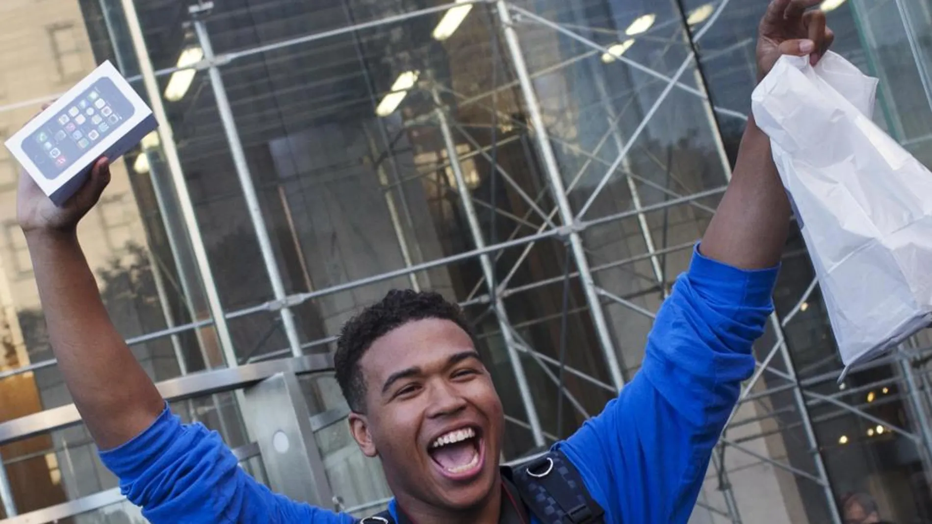 Un comprador sale con un iPhone de una tienda Apple en Nueva York