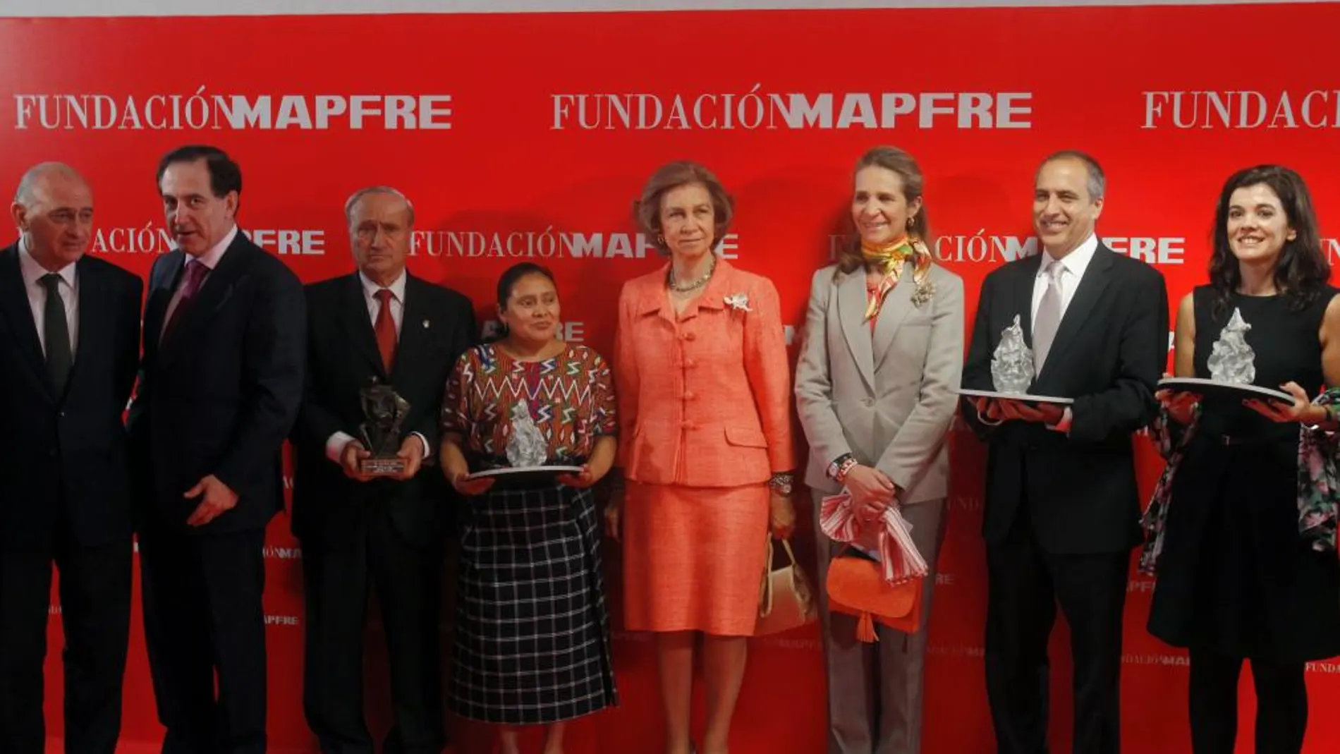 La Reina y la Infanta Elena posan tras la entrega de los Premios Sociales 2012 Fundación Mapfre con su presidente, Antonio Huertas (i), y los galardonados