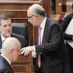 Duran Lleida pasa por delante de Mariano Rajoy y Cristóbal Montoro mientras conversan en el hemiciclo. Al lado, Sáenz de Santamaría