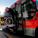 Serafín, conductor del servicio especial "puerta a puerta"de la EMT, ayuda a Juan a bajar del autobús adaptado. El servicio "puerta a puerta"que la EMT Valencia ofrece a personas con discapacidad se automatiza con una nueva aplicación móvil para que los usuarios que necesiten un transporte especial lo tengan a un "solo clic", casi en tiempo real y si tener que solicitarlo hasta 48 horas antes. EFE/Manuel Bruque