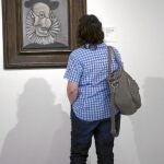 Una visitante de la exposición en el Museo Picasso contempla el retrato que el artista malagueño realizó a su secretario Jaume Sabartés