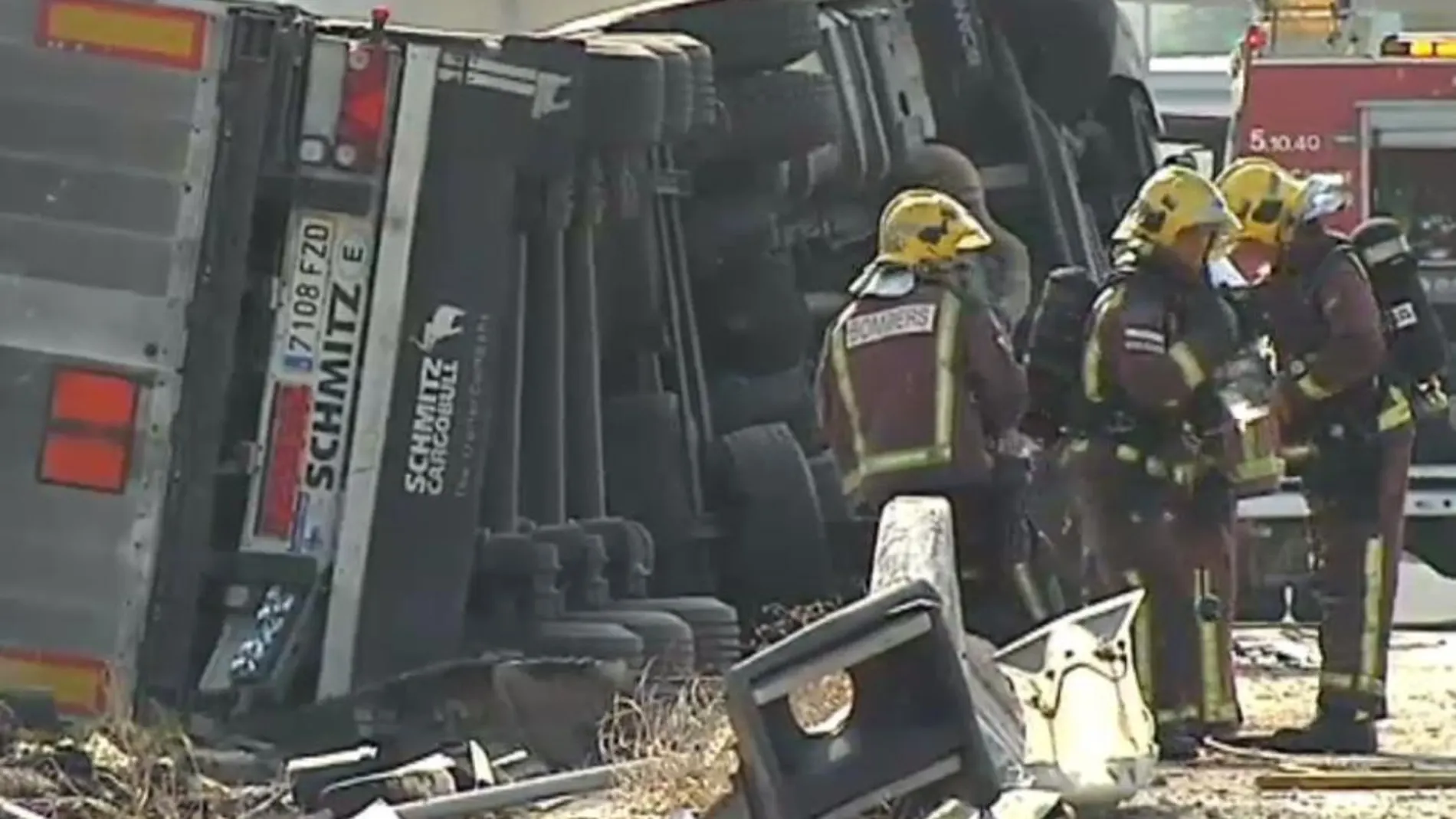 Los bomberos trabajan junto al camión siniestrado