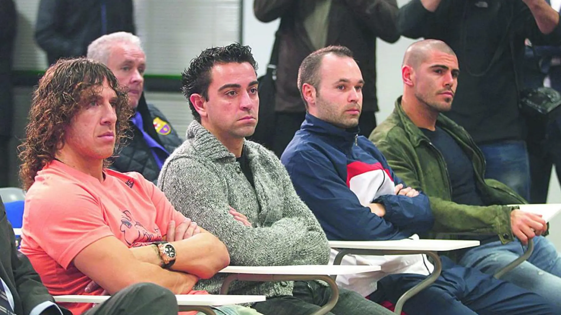 Barcelona's Carles Puyol, Xavi Hernandez, Andres Iniesta and Victor Valdes (front row, L-R) listen during a news conference held by Barcelona's president Sandro Rosell, after the club announced coach Tito Vilanova's saliva glandular cancer had reappeared, at Ciutat Esportiva in Sant Joan Despi near Barcelona December 19, 2012. La Liga leaders Barcelona have been rocked by news coach Vilanova is to have surgery on his saliva glands on Thursday, followed by chemotherapy and radiotherapy over the following six weeks. REUTERS/Gustau Nacarino(SPAIN - Tags: SPORT SOCCER)