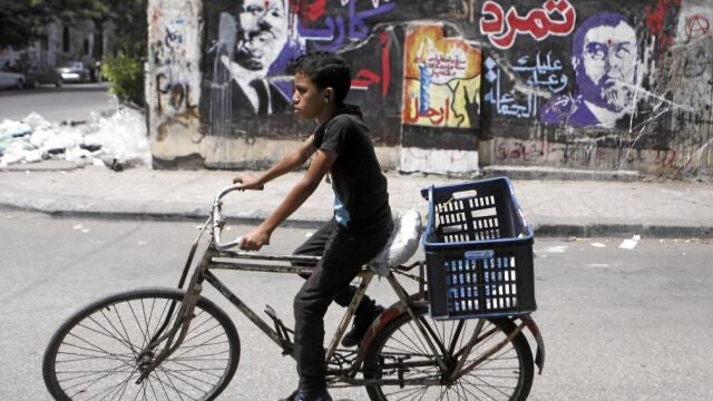 Un niño pasa frente a un grafiti con la imagen de Mursi, en El Cairo