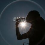 Una mujer se refresca en una de las últimas olas de calor / Efe