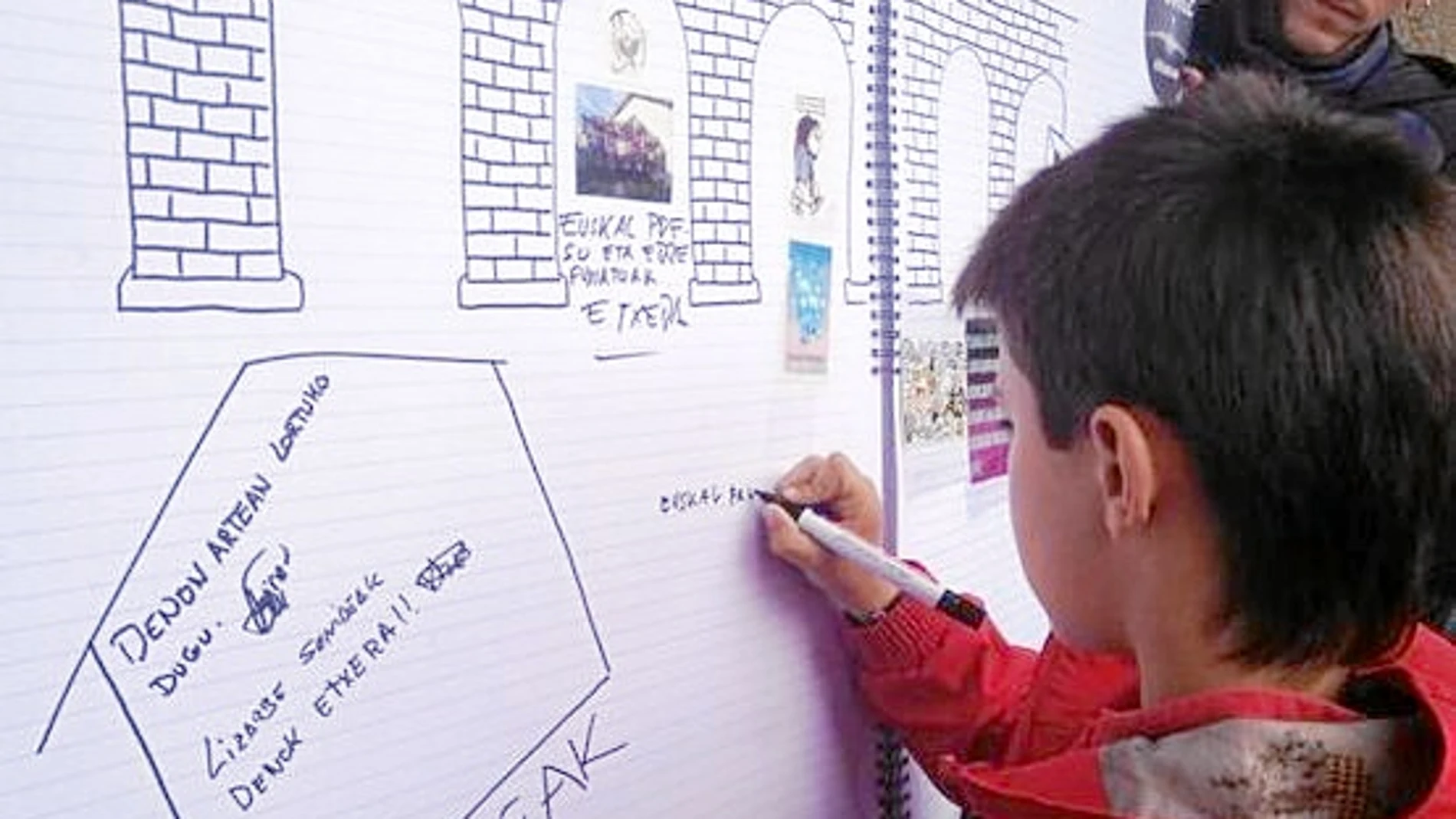 «EUSKAL PRESOAK ETXERA». Un niño de apenas 10 años escribe en el mural de homenaje a la etarra Inés del Río: «Presos vascos a casa»