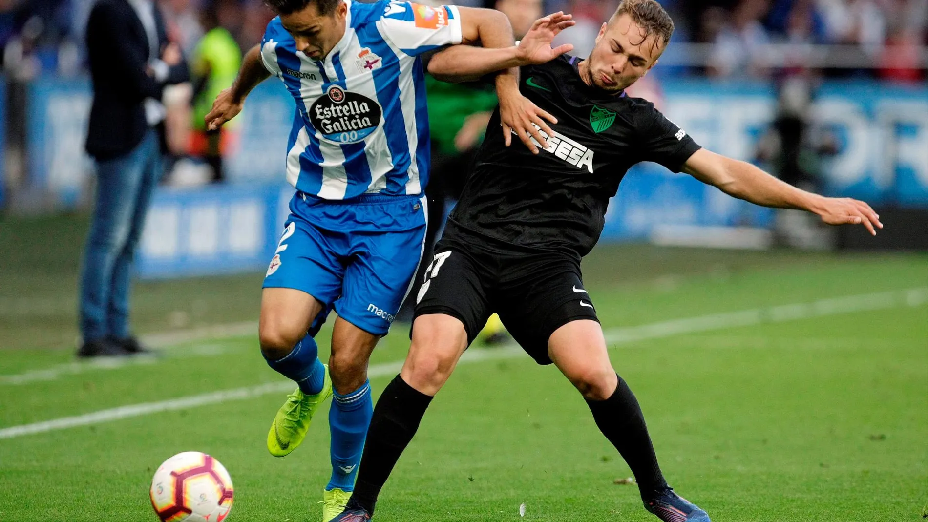 El defensa del Deportivo de La Coruña, David Simón (i), ante el centrocampista del Málaga, Javier Ontiveros (d), durante el partido de LaLiga Santander disputado en Riazor / Foto: Efe