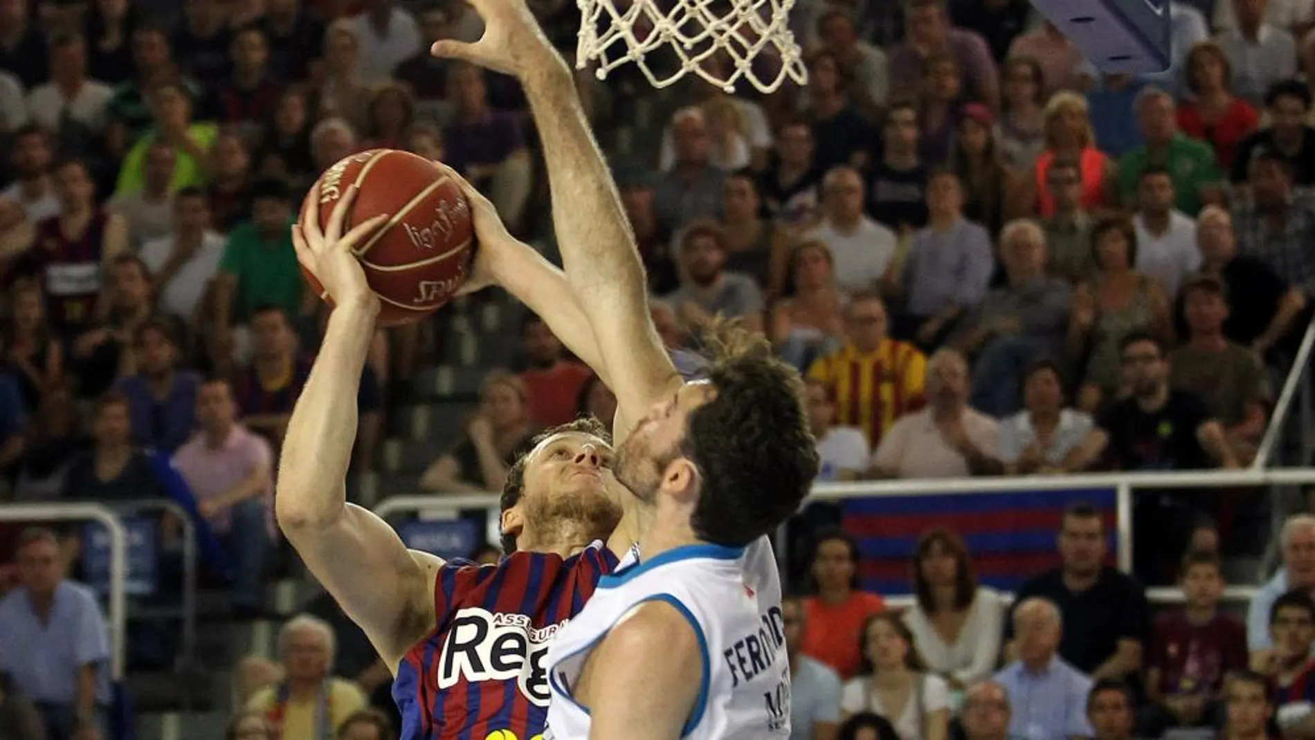 El alero británico del FC. Barcelona Regal Joe Ingles (i) intenta canasta ante el alero del Real Madrid Rudy Fernández, durante el cuarto partido de la final de Liga ACB