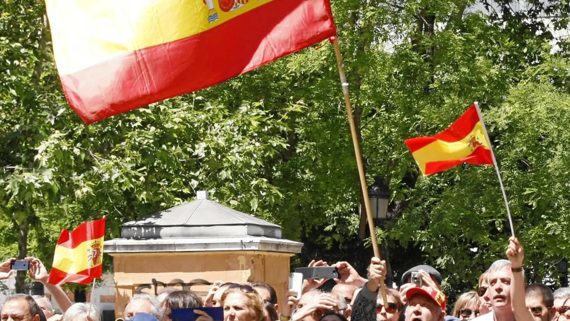 Los asistentes al acto ondean la bandera de España entre vítores al Rey