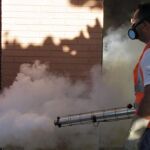 Un trabajador de la salud fumiga para combatir el dengue