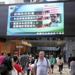 Una pantalla de televisión de un centro comercial de Hong Kong muestra las últimas noticias acerca del ex empleado de la CIA, Edward Snowden, ayer sábado, tras conocerse que EE UU le acusa de espionaje y que pedirá su extradición.