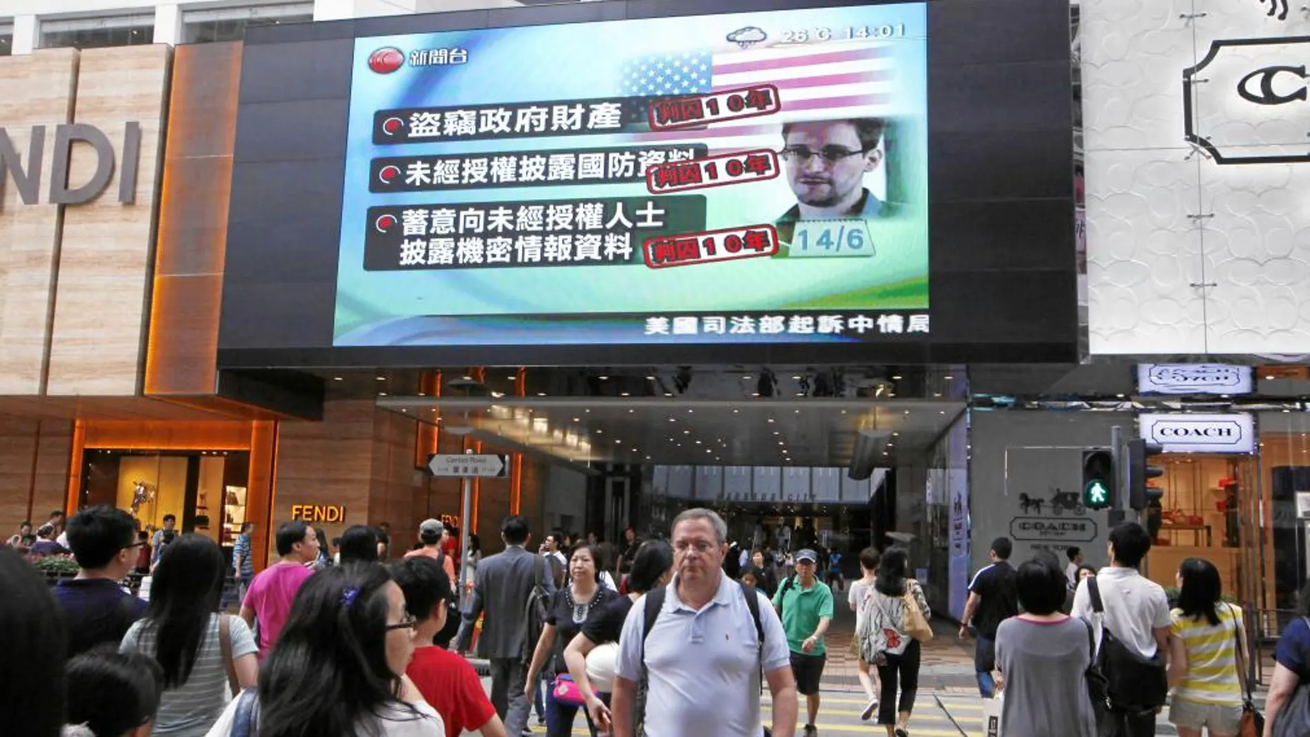 Una pantalla de televisión de un centro comercial de Hong Kong muestra las últimas noticias acerca del ex empleado de la CIA, Edward Snowden, ayer sábado, tras conocerse que EE UU le acusa de espionaje y que pedirá su extradición.