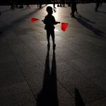 Un niño sostiene dos banderas en la plaza de Tiananmen en Pekín , China