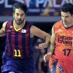 El escolta del Barcelona Juan Carlos Navarro intenta superar la defensa del escolta del Valencia Basket Rafa Martínez