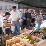 El líder socialista, Óscar López, compra fruta en un mercado durante su visita a la localidad de Benavente