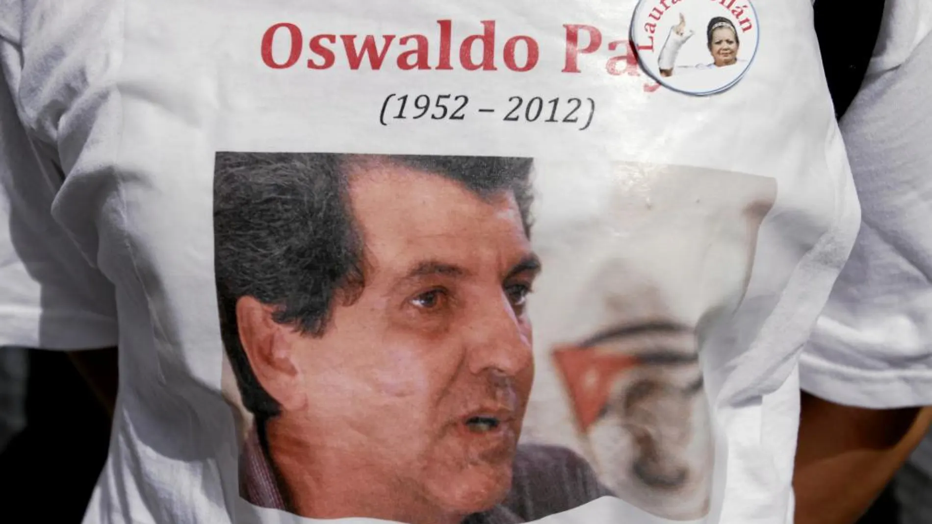Una representante de las «Damas de Blanco» lleva puesta un camiseta con la foto del fallecido Oswaldo Payá