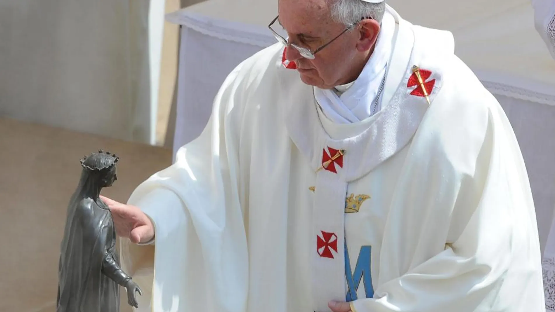 El Papa Francisco toca una imagen de la Virgen Maria delante del Palacio Apostólico