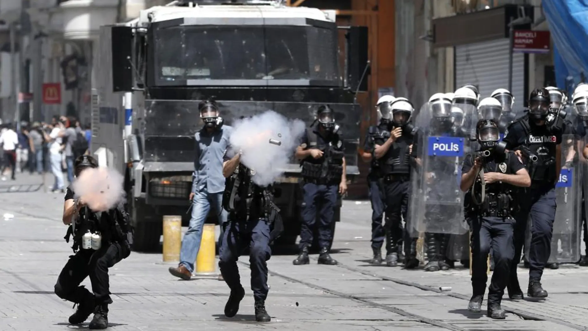 Policías antidisturbios turcos disparan botes de gas lacrimógeno contra los manifestantes durante una protesta contra la planeada construcción de un centro comercial en la Plaza Taksim, en Estambul, Turquía, hoy, viernes 31 de mayo de 2013.