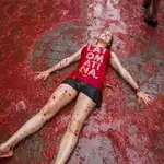Una chica tendida en el suelo teñido de rojo en la fiesta de la Tomatina