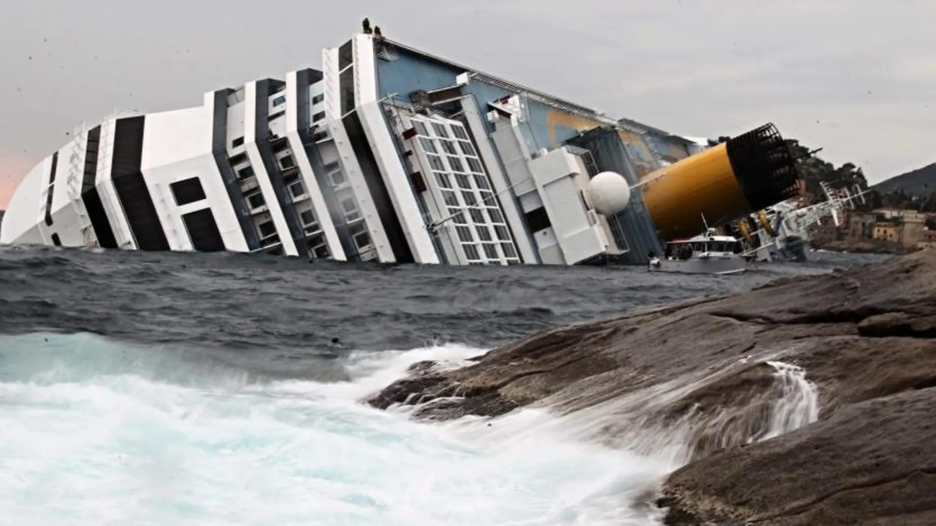 Las olas chocan contra las rocas cerca del buque crucero Costa Concordia. EFE/Massimo Percossi