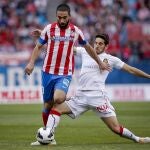 El centrocampista turco del Atlético de Madrid, Arda Turan (i) pelea un balón con el defensa del Mallorca Pedro Bigas