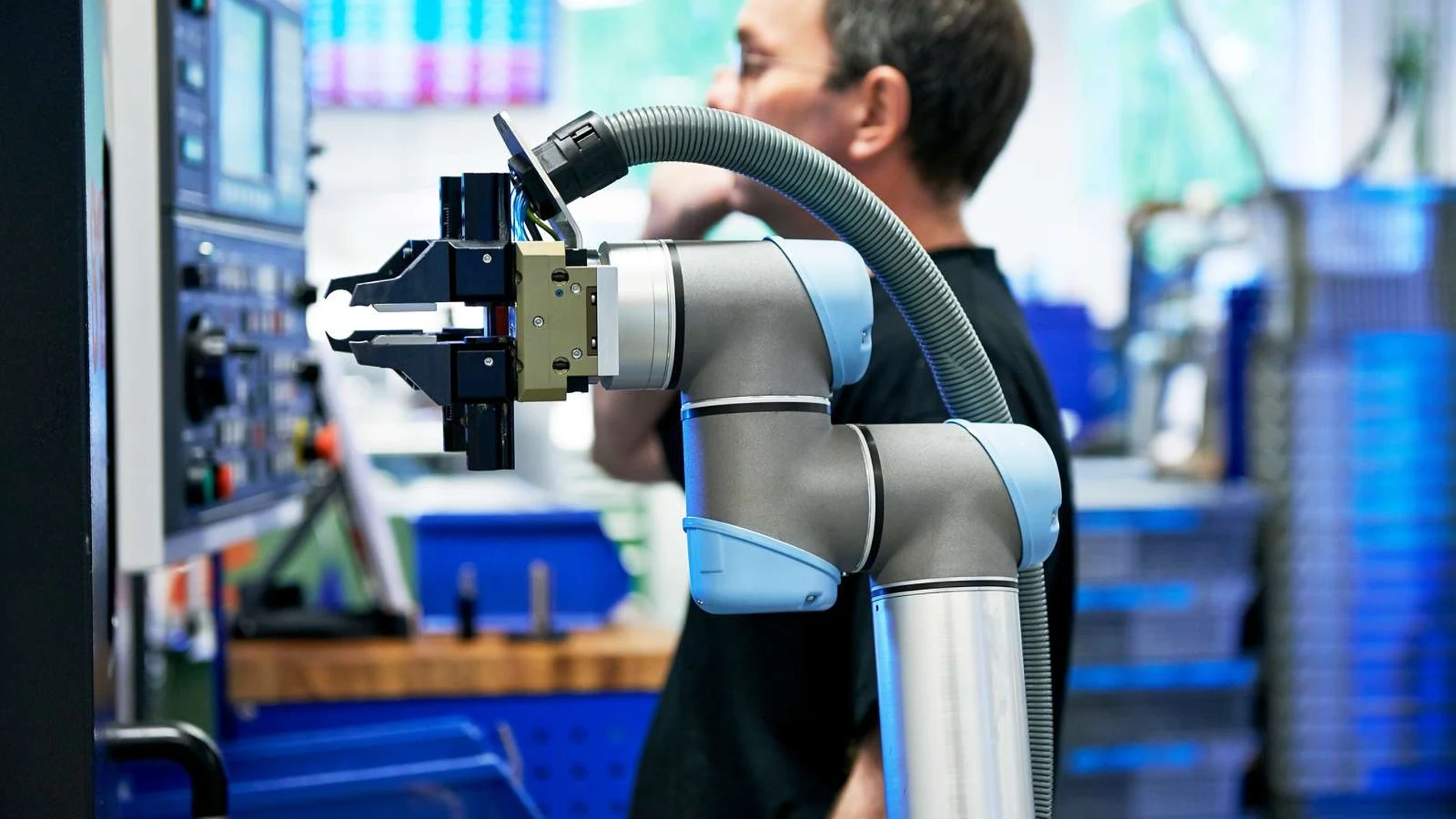 Un robot junto a un empleado en una fábrica