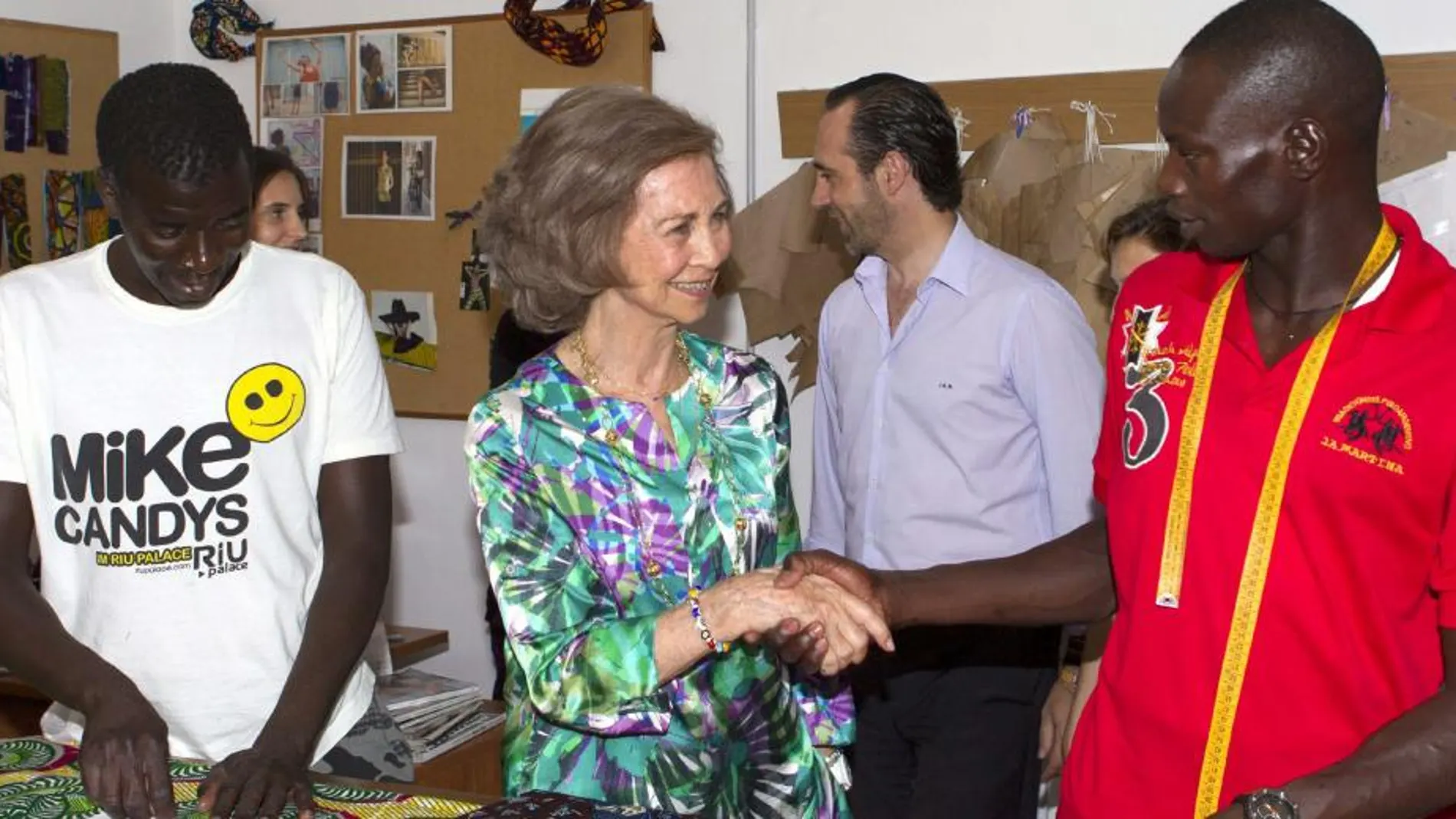 La Reina Sofía observa algunas de las telas en el taller de confección "koluté"(confianza en senegalés), durante la visita a la Fundación Joana Barceló, una de las sedes de Cáritas Mallorca, en Palma